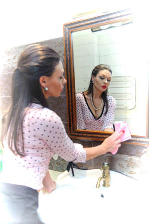 woman wash the mirror and looking into itの写真素材