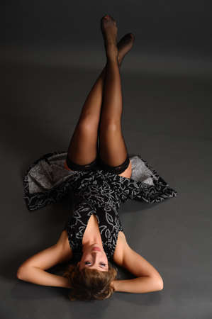 girl in stockings and a dress lying on the floorの写真素材