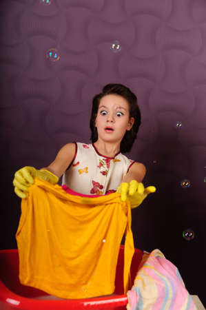 Girl wash clothes in a bucketの写真素材