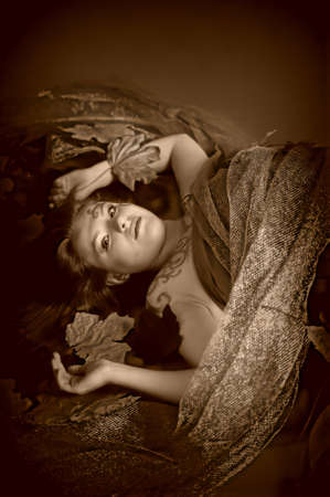 Autumn image with a girl lying in fallen leavesの写真素材