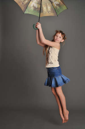 Girl with umbrella jumpingの写真素材
