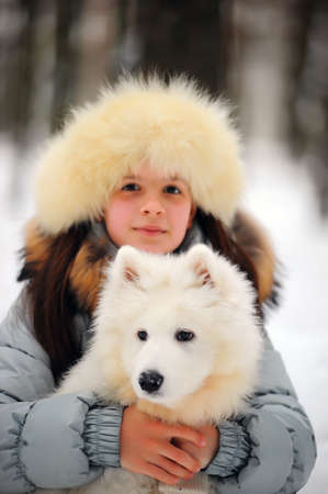 girl in winter with a white dogの写真素材