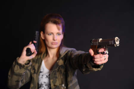 beautiful woman armed with a gunの写真素材
