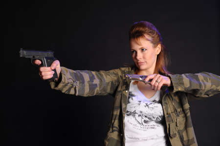 beautiful woman armed with a gunの写真素材