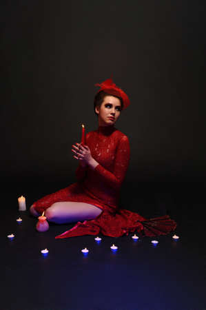 woman in red dress surrounded by candlesの写真素材