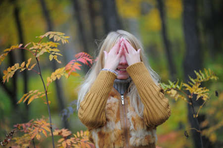 beautiful young blond woman in autumn parkの写真素材