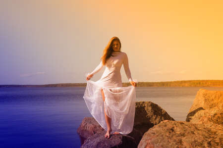 woman in a white dress at lakeの写真素材
