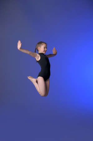 Gymnast girl jumping studioの写真素材