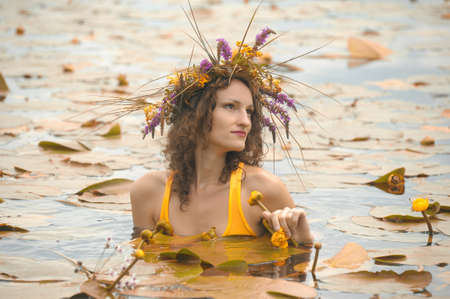 mermaid in the water with a wreath on head