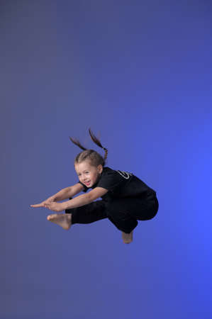 Gymnast girl jumping studioの写真素材