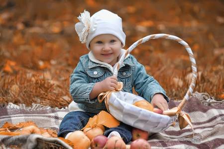 The little girl with a basket of apples の写真素材