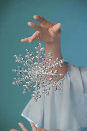 Woman hand holding big holiday snowflakeの写真素材