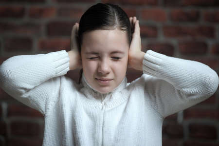 girl  with his hands covering his ears の写真素材