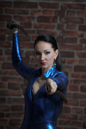 girl in a blue suit with a fitting close katana in handsの写真素材