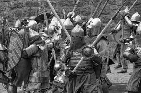 Fight between the pedestrian knights in a heavy armor in a medieval castle against a stone wall ,  Vyborg,Russia, july-31のeditorial素材