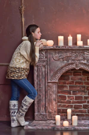 The girl the teenager at a fireplace with candlesの写真素材