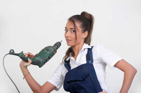 Closeup of a beauty girl with drill machine on white background