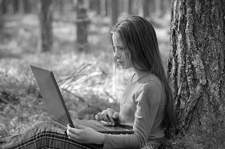 girl with laptop in the woodsの写真素材