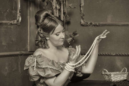 the medieval lady with a pearl necklace in handsの写真素材