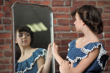 the girl admires itself in a mirrorの写真素材