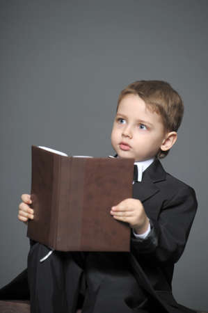 Boy in a suit with a bookの写真素材