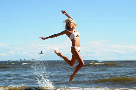 Young beautiful girl doing gymnastic jumps outdoorsの写真素材