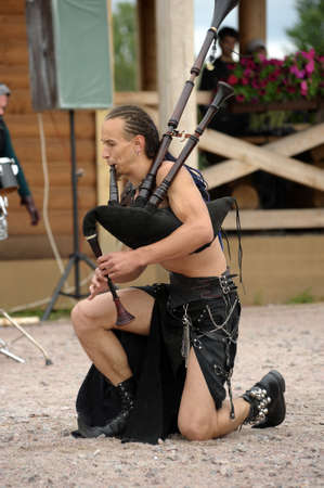 Unidentified musicians in medieval clothes play ancient musical instruments at festival Iron...