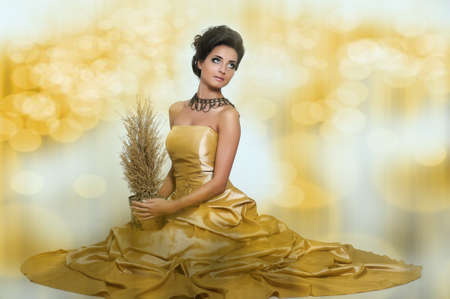Beautiful girl in golden dressの写真素材