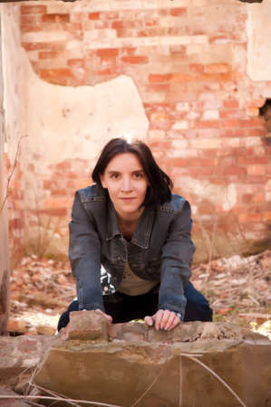girl on the ruins of the destroyed brick houseの写真素材