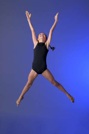 Gymnast girl jumping studioの写真素材