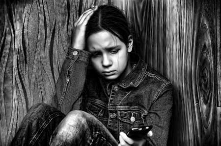 The upset girl with a mobile phoneの写真素材