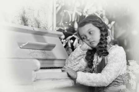 sad girl near the pianoの写真素材