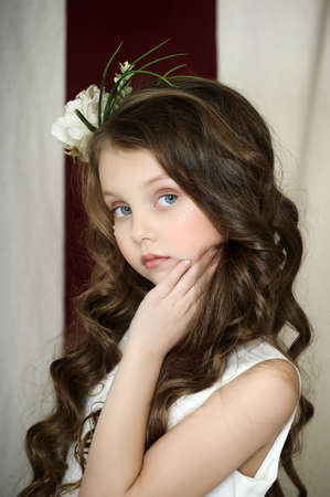 portrait of a beautiful girl with curly hair and a flower in her hairの写真素材