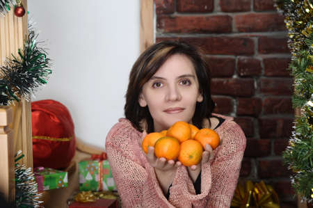 young woman with tangerinesの写真素材