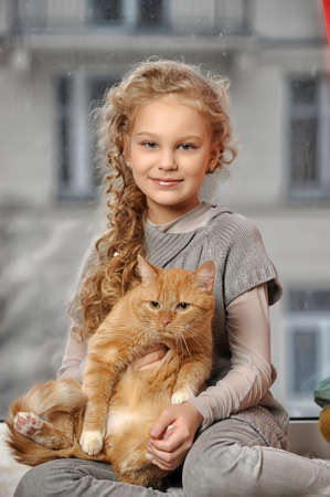 Teen girl with a red cat in her armsの写真素材
