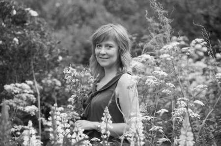 Happy woman in garden with flowers の写真素材