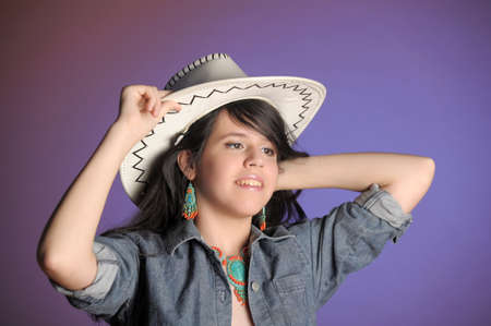 Young girl wearing cowboy hat in the studioの写真素材