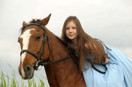 Teen girl in a dress on a horseの写真素材