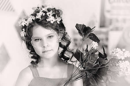 portrait of a girl with flowers in her hair, and in the hands ofの写真素材