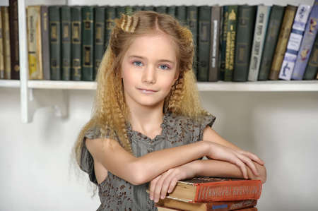 girl holding a pile of books in the library