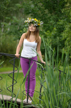 girl in a wreath from the field lights on the bridgeの写真素材