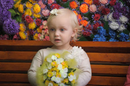 Child near the benches with flowers on the backgroundの写真素材