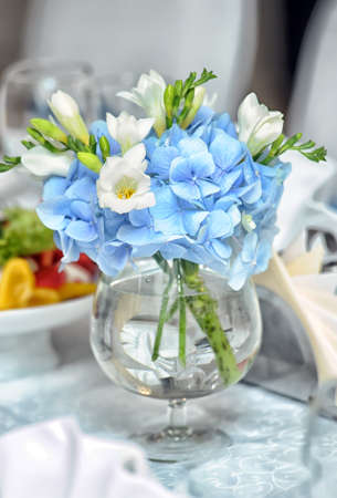 Soft white and blue flowers in a glass.の写真素材