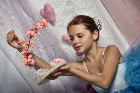 young ballerina in a blue skirt on a floral backgroundの写真素材