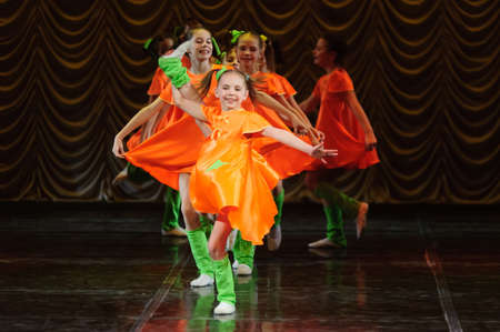 children in dresses dancing on stage