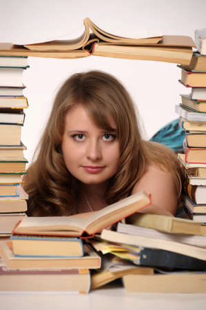 a girl student in the middle of large number of booksの写真素材
