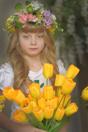 Girl with a bouquet of yellow tulips の写真素材