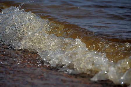 Frothy ocean wave on a sandy beach 
