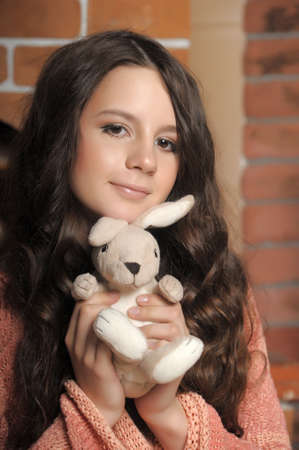 Beautiful teen girl with a toy rabbit in hands.の写真素材