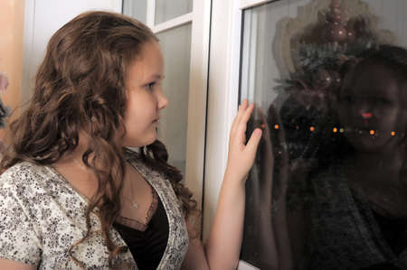 Teen girl looking out the window.